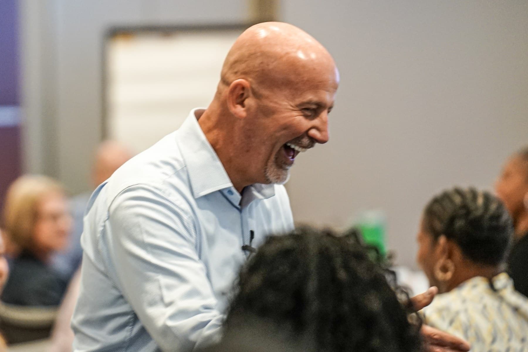 Steve Lowisz in a light-blue shirt talking with participants during a session